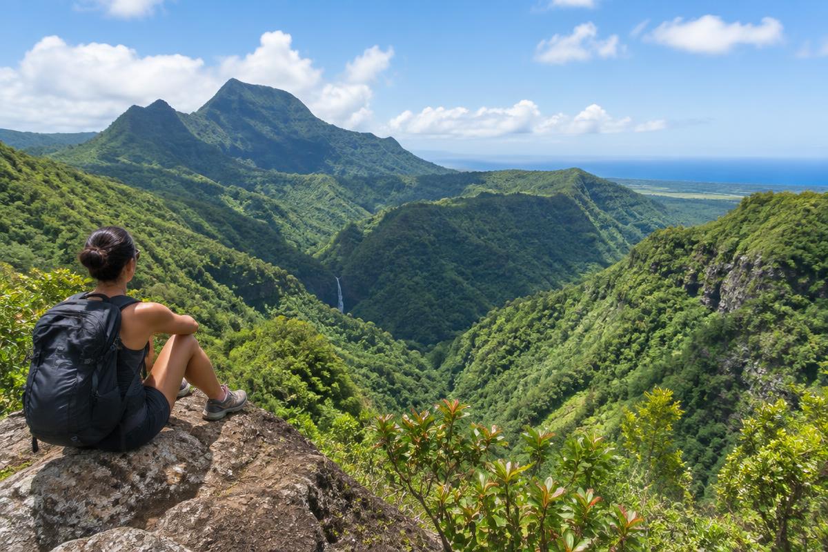 Hiker overlooking the green valleys of Black River Gorges in Mauritius