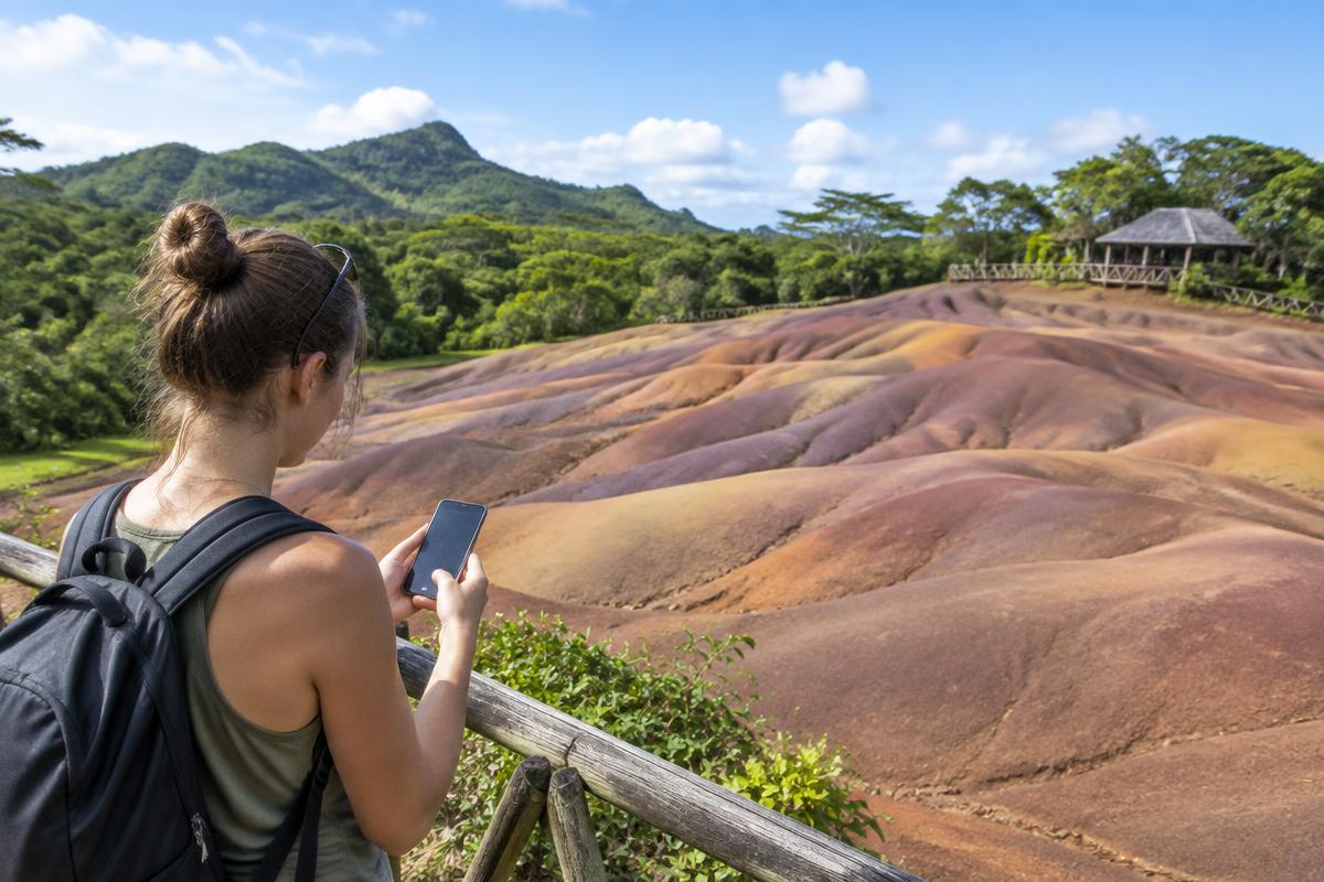 Traveler using a phone at the Seven Coloured Earth in Chamarel Mauritius